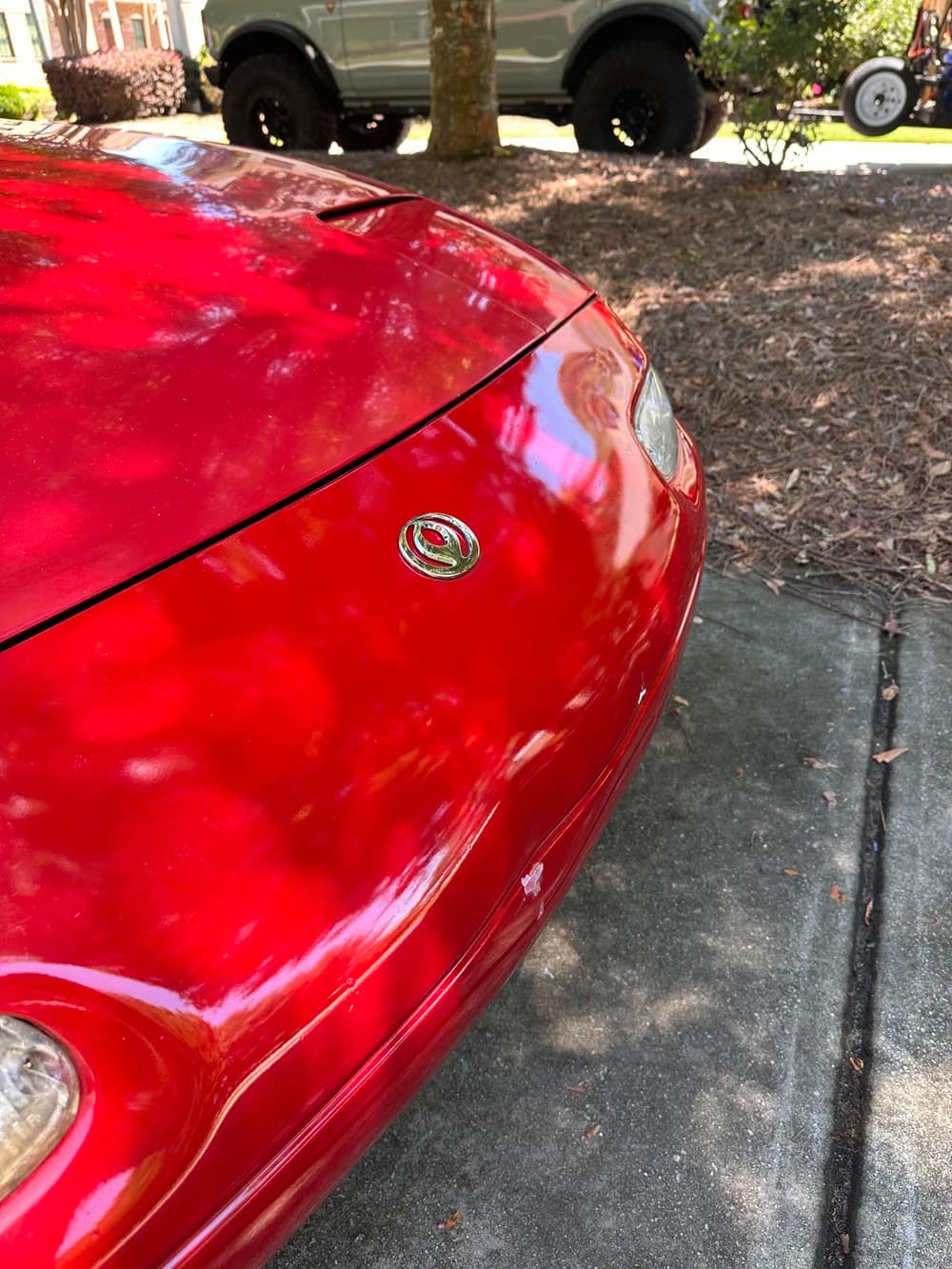 Red car hood after a Cosmic Gloss detail, with glossy paint